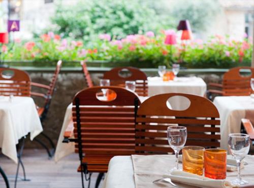 a restaurant with tables and chairs with wine glasses at Angela Boutique Serviced Residence in Ho Chi Minh City