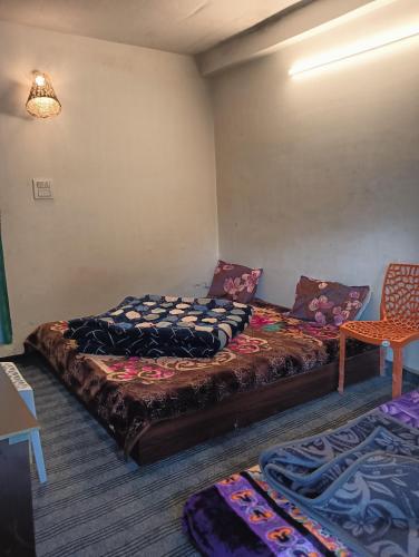 a room with two beds and a chair in it at L'Ashrum Cafe & Inn in Tosh