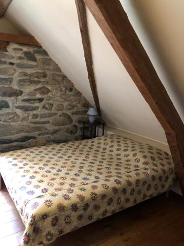 a bed in a room with a stone wall at Bergerie authentique au cœur des Pyrénées in Eaux-Bonnes