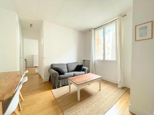 un salon avec un canapé et une table dans l'établissement Charming Apartment, Paris Centre, à Paris