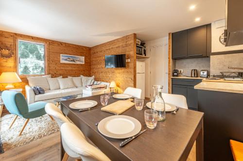 une cuisine et un salon avec une table et des chaises dans l'établissement Smartstay - Appartement au pied des pistes, à Méribel