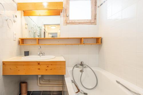 une salle de bain avec un lavabo et une baignoire dans l'établissement Smartstay - Appartement au pied des pistes, à Méribel