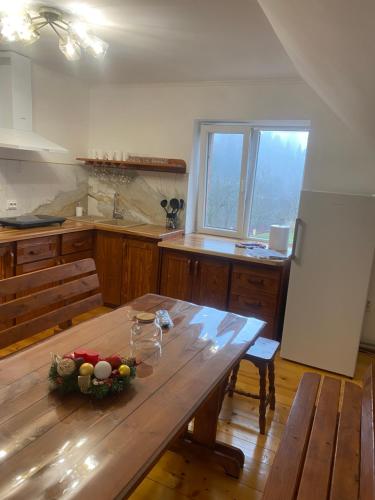 a kitchen with a wooden table with a bowl of fruit on it at Batkivska Svitlitsa NEW Без господарів in Slavske