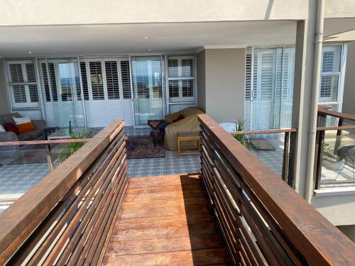 a balcony with a wooden railing and a living room at Seaviews Queen in Westbrook