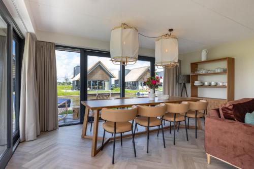 a kitchen and dining room with a table and chairs at Aan Het Water 'Wetterhaghe' optioneel met E-Sloep in Heeg