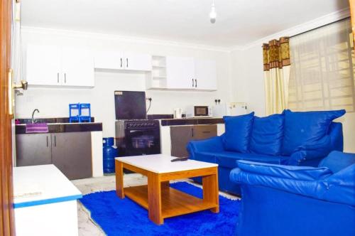 a living room with blue couches and a coffee table at Pazuri in Ruiru