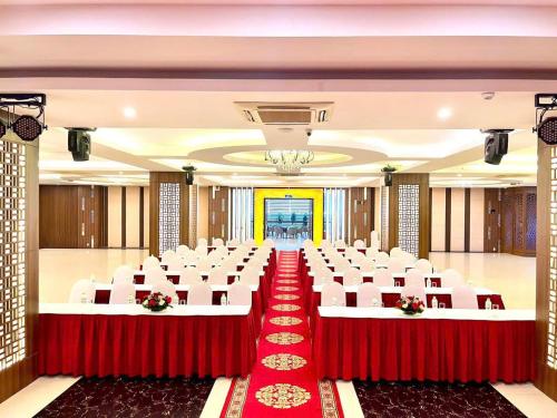 a banquet hall with red and white chairs and tables at Muong Thanh Quy Nhon Hotel in Quy Nhon
