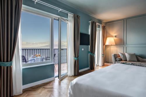 a hotel room with a bed and a large window at Imperial Hotel Tramontano in Sorrento