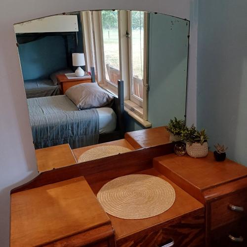 a bedroom with a mirror and a bed and a bed sidx sidx sidx at Warradale Lodge and Mini Golf in Palgarup