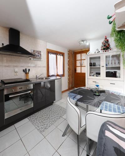 une cuisine avec une table et un comptoir dans l'établissement La Charlotte, à Sallanches