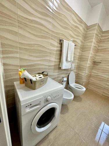 a bathroom with a washing machine and a toilet at Valamar Garden Apartment in Mullini i Danit