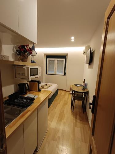 a small room with a kitchen and a bedroom at MCR Barreiro - O Limoeiro in Lavradio