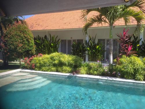 een zwembad voor een huis met planten bij Villa Bukit Sweet Home in Uluwatu