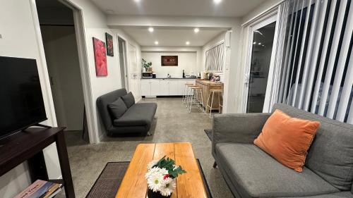 a living room with a couch and a table at Cozy 1 Bed 1 Bath Studio Kingsland - Morningside in Auckland