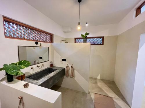 a bathroom with a large sink and a large mirror at Charleston's Ahangama in Ahangama