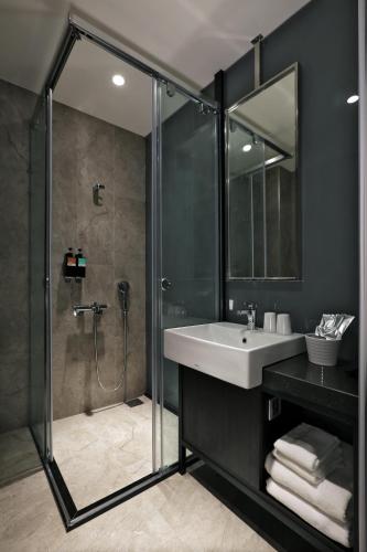 a bathroom with a shower and a sink and a glass shower stall at Miller Inn in Taichung