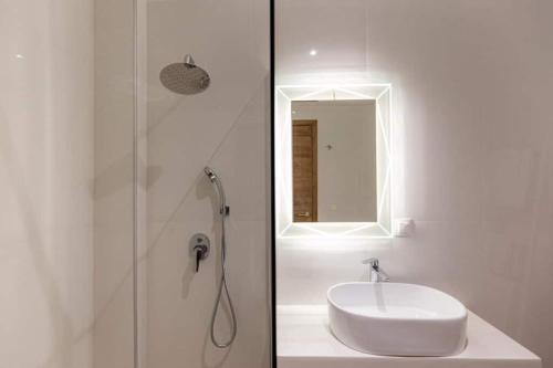 a white bathroom with a sink and a shower at Blue Sea Suites in Afitos