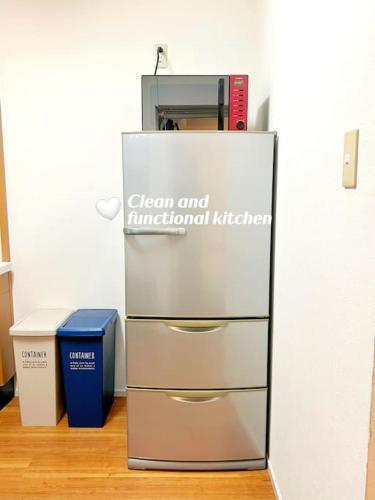 a metal refrigerator next to a blue box on a wooden floor at Easily to Nishi-Nippori Shibuya Asakusa For 10 in Tokyo