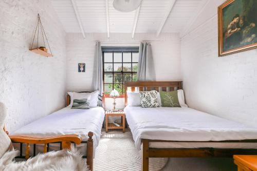 a room with two beds and a window at Red Brick Seaview Lof,Green Oasis,Massage in Kingston Beach