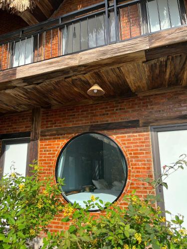 a round window on a brick building with a window at Tam Coc Golden Fields in Ninh Binh
