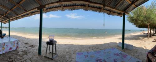 a table and chairs on a beach with the ocean at Oasis club in Cap Skirring