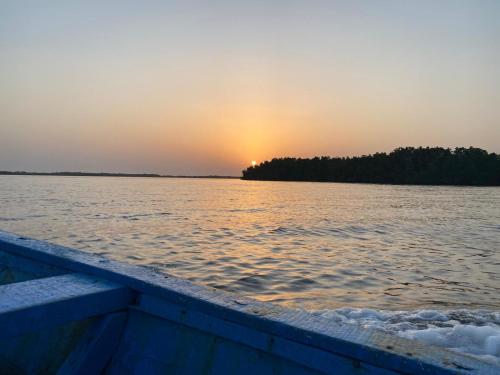 a boat on the water with the sunset in the background at Oasis club in Cap Skirring
