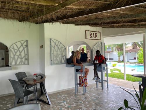 a group of people sitting at a bar at Oasis club in Cap Skirring