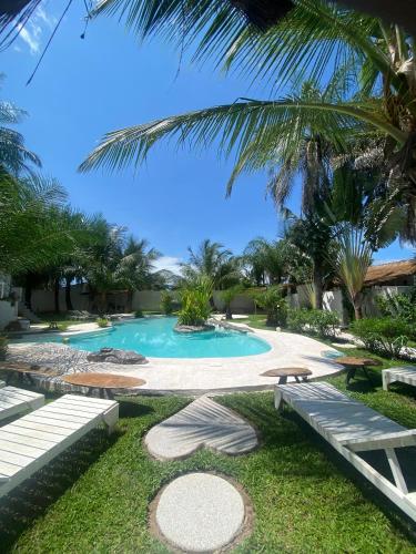 a swimming pool with palm trees in a resort at Oasis club in Cap Skirring