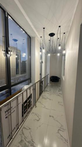 einen Flur in einem Gebäude mit einem großen Fenster in der Unterkunft 2-х комнатные апартаменты на Экспо in Astana