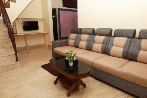 un soggiorno con un divano e un tavolo di Vagamon misty Hills Resort a Vagamon