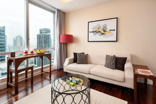 a living room with a couch and a table at Sky Villas Apartments in Bangkok