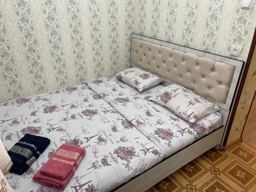 a bed with a white comforter and pillows on it at Апартамент зал спальня кухня in Yunusobod