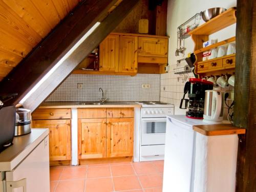 a kitchen with wooden cabinets and a white stove top oven at Ferienhof Hohe in Hiltpoltstein