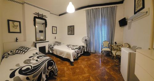 1 dormitorio con 2 camas y espejo en Hostal Loyola, en Madrid