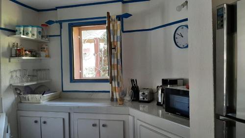 a kitchen with blue and white walls and a window at Teranga saly senegal in Saly Portudal