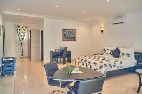 Una habitación de hotel con una cama, una mesa y sillas. en Guest Wharf - Côte Sauvage, en Pointe-Noire
