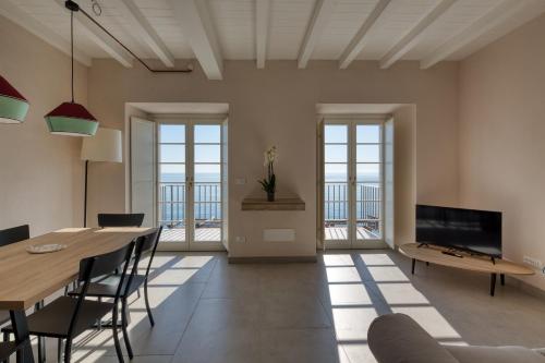 a living room with a table and chairs and a television at Campetti Apartments in Vesima