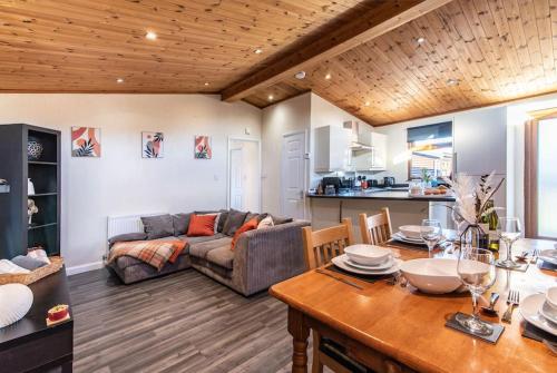 a living room with a couch and a table at Countryside log cabin with HOT TUB! in Swarkeston