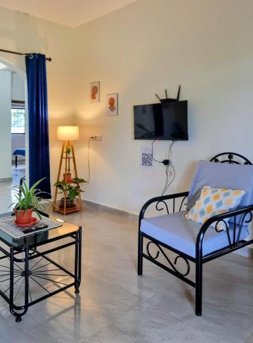 a living room with a chair and a table and a tv at Your perfect high standart cosy Home near Arambol with 2BHK in Arambol