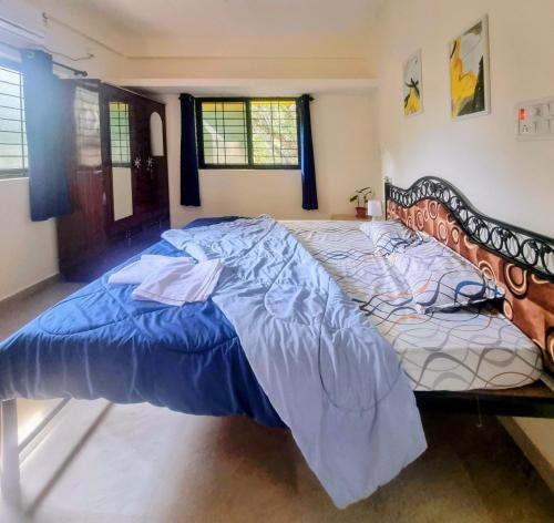 a large bed with a blue comforter in a bedroom at Your perfect high standart cosy Home near Arambol with 2BHK in Arambol