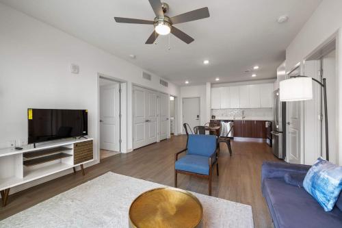 a living room with a blue couch and a tv at Modern Nulu 2BR CozySuites 08 in Louisville