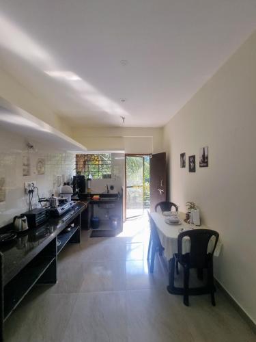 a large kitchen with a table and a dining room at Your perfect high standart cosy Home near Arambol with 2BHK in Arambol