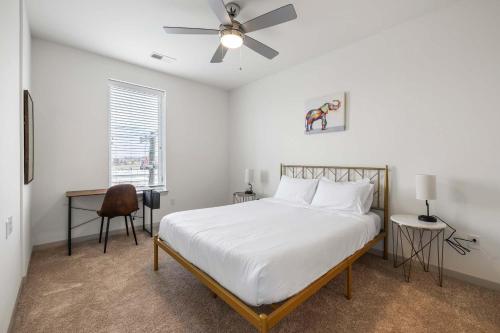 a white bedroom with a bed and a ceiling fan at Modern Nulu 2BR CozySuites 08 in Louisville