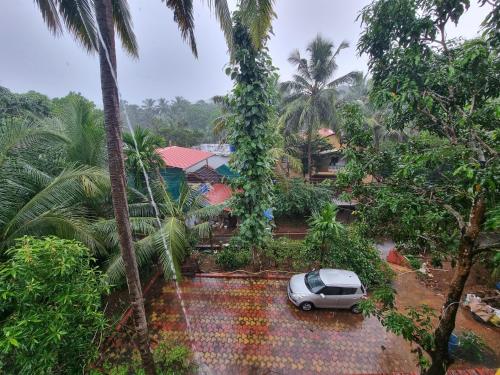 a car parked in front of a house with palm trees at Your perfect high standart cosy Home near Arambol with 2BHK in Arambol