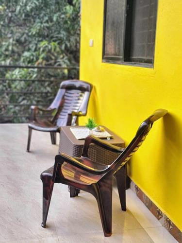 two chairs and a table on a yellow wall at Your perfect high standart cosy Home near Arambol with 2BHK in Arambol
