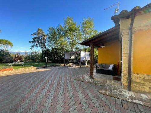 a building with a pavilion next to a brick driveway at Casolare del Maestrale - M&M Holiday House in Perugia