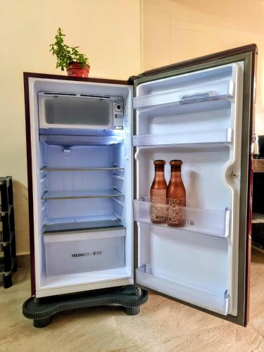 an open refrigerator with bottles inside of it at Your perfect high standart cosy Home near Arambol with 2BHK in Arambol