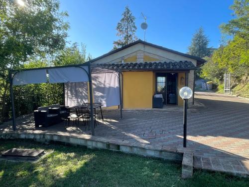 a tent in front of a house with a table at Casolare del Maestrale - M&M Holiday House in Perugia