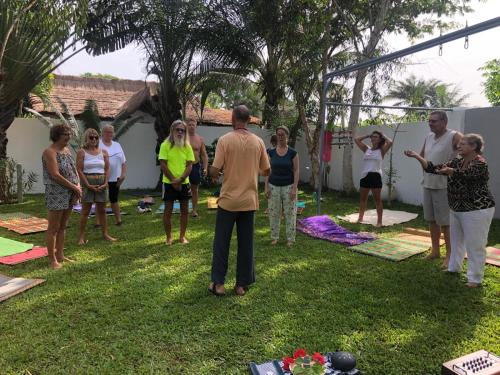 a group of people standing around in the grass at Oasis club in Cap Skirring