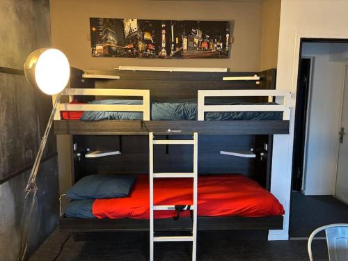 - une chambre avec 2 lits superposés et un lit rouge dans l'établissement Appart Nausicaa en plein centre-ville, à Le Touquet-Paris-Plage